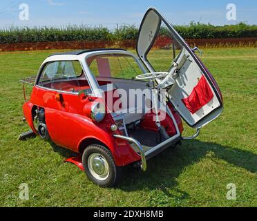 Classic red and white  BMW Isetta 300,  3 wheeled bubble car parked on grass Stock Photo