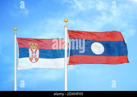 Serbia and Laos two flags on flagpoles and blue sky Stock Photo