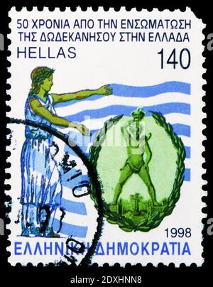 MOSCOW, RUSSIA - MARCH 23, 2019: Postage stamp printed in Greece shows Colossus of Rhodes with Greek flag, Greek History serie, circa 1998 Stock Photo