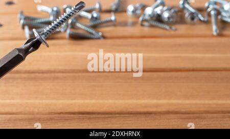 A screwdriver and self-cutters on a brown wooden background. Building tools to repair the house Stock Photo