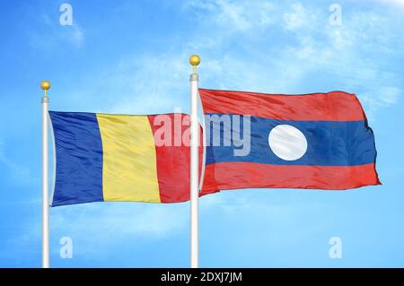 Romania and Laos. two flags on flagpoles and blue sky Stock Photo