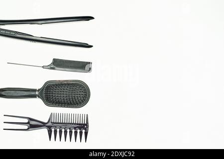 Female Hairdresser tools. Different types of combs and hair iron for straightening curly hairs on white background. Hair salon accessories with copy Stock Photo