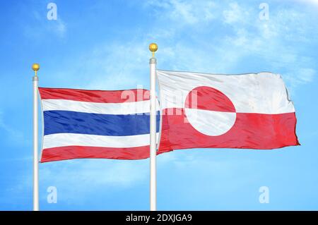Thailand and Greenland two flags on flagpoles and blue sky