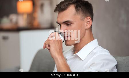 man drinking coffee relaxing on the couch at home Stock Photo
