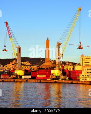 The handling of containers inside the port terminal behind the lantern December 13, 2020 Genoa Italy Stock Photo
