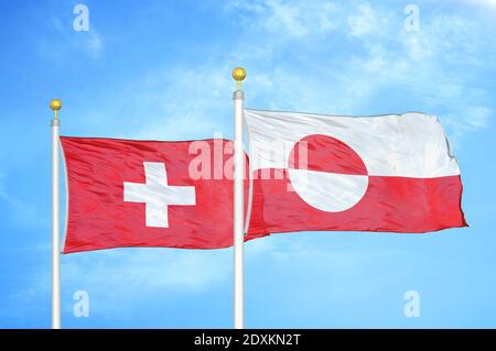 Switzerland and Greenland two flags on flagpoles and blue sky