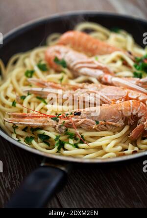 Handmade Tagliatelle with Prawns and Zucchini on a pan. Stock Photo