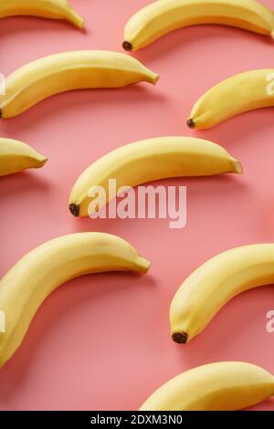 Bright pattern of yellow bananas on a pink background. View from above. Flat lay. Fruit patterns Stock Photo