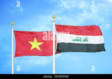 Vietnam and Iraq two flags on flagpoles and blue sky Stock Photo