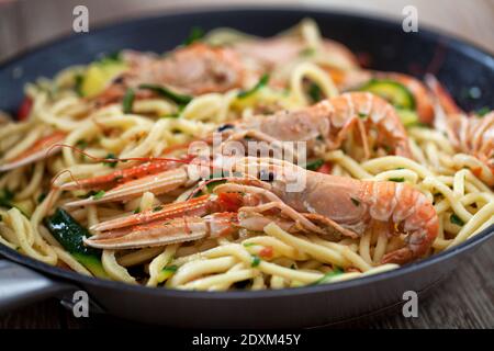 Handmade Tagliatelle with Prawns and Zucchini on a pan. Stock Photo