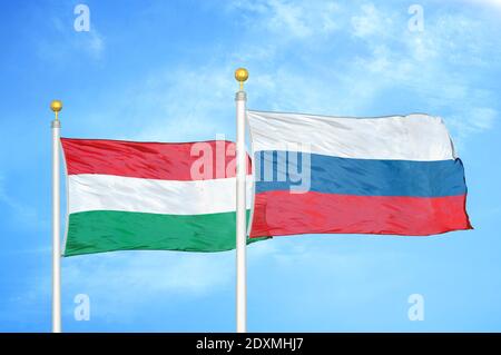 Hungary and Russia two flags on flagpoles and blue cloudy sky Stock Photo
