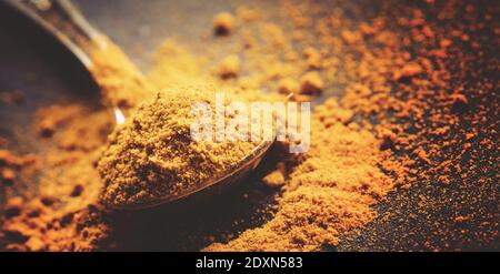Ground turmeric or curcuma, black background, close-up shot, selective focus Stock Photo