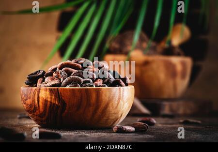 Unpeeled cocoa bean on wooden rustic background, close-up. Copy space Stock Photo