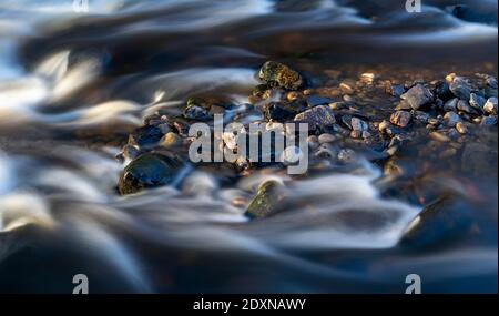 Long exposure of river flowing past rocks on Cotterdale Beck, Yorkshire Dales National Park, UK. Stock Photo