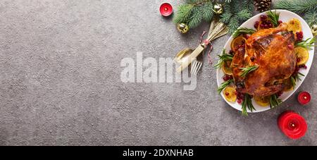 Christmas table with baked chicken is festively decorated with candles. Stock Photo