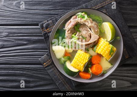 Delicious Caldo de res Mexican beef shank soup with vegetables close-up in a bowl on the table. horizontal top view from above Stock Photo
