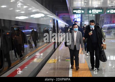 (201224) -- CHONGQING, Dec. 24, 2020 (Xinhua) -- Passengers walk to board the Fuxing high-speed train G8608 bound for Chengdu East Railway Station in southwest China's Sichuan Province, at Shapingba Railway Station in southwest China's Chongqing on Dec. 24, 2020. On Thursday morning, with G8608 and G8607 trains respectively pulling out of Chongqing Shapingba Railway Station and Chengdu East Railway Station, the Fuxing CR400AF trains plying on the railway linking Chengdu, capital of Sichuan Province, and Chongqing Municipality were officially put into operation at a speed of 350 km/h, reducing Stock Photo