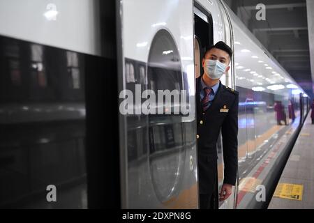 (201224) -- CHONGQING, Dec. 24, 2020 (Xinhua) -- A staff member works on the Fuxing high-speed train G8608 bound for Chengdu East Railway Station in southwest China's Sichuan Province, at Shapingba Railway Station in southwest China's Chongqing on Dec. 24, 2020.  On Thursday morning, with G8608 and G8607 trains respectively pulling out of Chongqing Shapingba Railway Station and Chengdu East Railway Station, the Fuxing CR400AF trains plying on the railway linking Chengdu, capital of Sichuan Province, and Chongqing Municipality were officially put into operation at a speed of 350 km/h, reducing Stock Photo