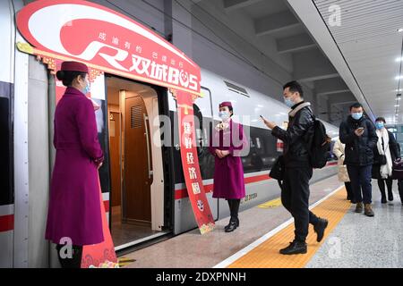 (201224) -- CHONGQING, Dec. 24, 2020 (Xinhua) -- Passengers walk to board the Fuxing high-speed train G8608 bound for Chengdu East Railway Station in southwest China's Sichuan Province, at Shapingba Railway Station in southwest China's Chongqing on Dec. 24, 2020.  On Thursday morning, with G8608 and G8607 trains respectively pulling out of Chongqing Shapingba Railway Station and Chengdu East Railway Station, the Fuxing CR400AF trains plying on the railway linking Chengdu, capital of Sichuan Province, and Chongqing Municipality were officially put into operation at a speed of 350 km/h, reducing Stock Photo