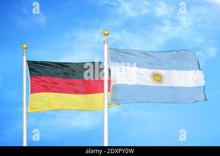 Germany and Argentina two flags on flagpoles and blue cloudy sky Stock Photo