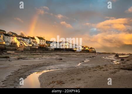 Appledore, North Devon, England. Thursday 24th December 2020. UK Weather. After a night of torrential rain and gale force winds, at sunrise on Christmas Eve the storm clouds break over the North Devon coast and a rainbow appears over the River Torridge estuary at the small coastal village of Appledore.Terry Mathews. Alamy Live News. Credit: Terry Mathews/Alamy Live News Stock Photo