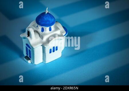 Macro photography of a small white church with blue dome, typical souvenir made in Greece, Santorini island, southern Europe. Stock Photo