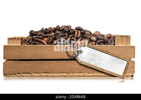 Closeup of roasted coffee beans in a small wooden crate with empty label, isolated on white background with reflections. Stock Photo
