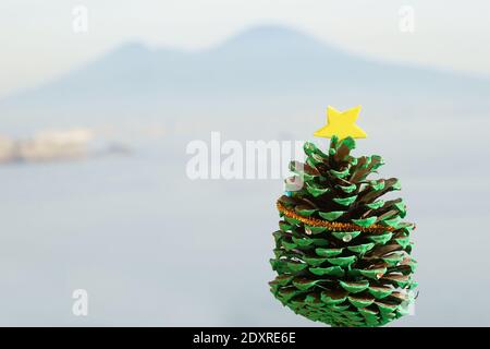 Miniature christmas tree - like decoration made of pine cone over Vesuvius background Stock Photo