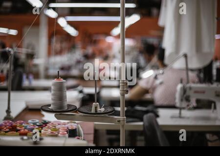 sewing machine and bobbins of multi-colored thread on the background of a sewing factory. High quality photo Stock Photo