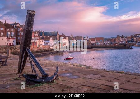 An ancient anchor on the harbour wall at Whitby. Stock Photo