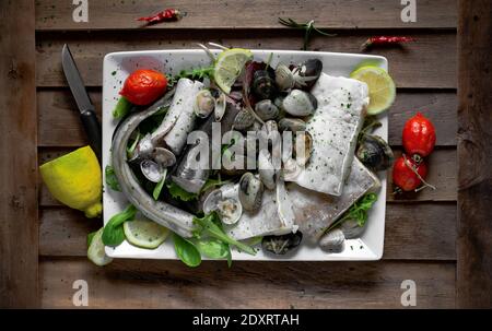 Typical Neapolitan raw fish dish of the Christmas period. Capitone, eel, cod and clams Stock Photo