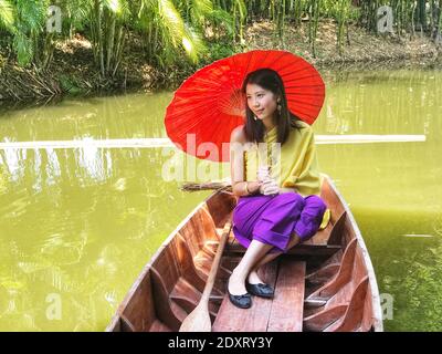 Woman With Umbrella Sitting In Boat On Lake