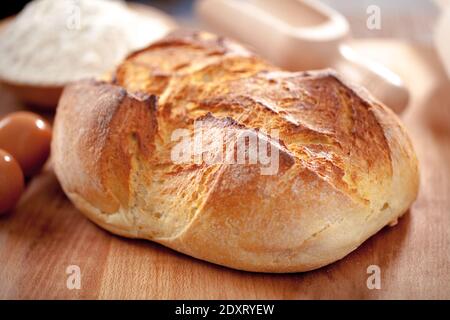 Freshly rustic loaf of bread isolated on wooden table background Stock Photo