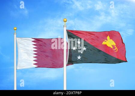 Qatar and Papua New Guinea two flags on flagpoles and blue cloudy sky Stock Photo