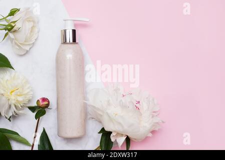 jar with metallic lid for skin care cosmetics - cream or scrub. mockup template. pink background with flowers Stock Photo