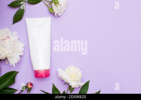 Beauty background with cosmetic cream product, with blossom flowers on pastel background with copy space. Spring skin care trends, top view, frame, fl Stock Photo