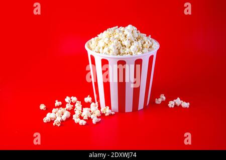 Striped box with popcorn on red background Stock Photo