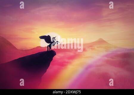 Wild pegasus silhouette on a cliff edge against a pink paradise sunset. Magical background, surreal creature as unicorn with wings, over the rainbow. Stock Photo