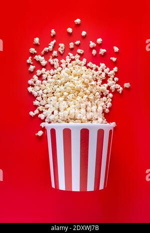 Striped box with popcorn on red background Stock Photo