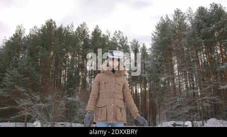 Woman using virtual reality glasses in winter forest Stock Photo