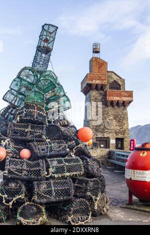 Alternative Christmas tree made of lobster pots covered with lights beside the Rhenish Tower on the pier in the harbour at Lynmouth, Devon UK Stock Photo