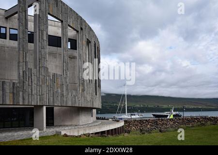 The Hof, Cultural and Conference Center, Akureyri, North Iceland. Part of Eyjafjordur with moored sailing boats can be seen next to the building. Stock Photo