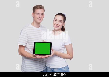 Couple Showing Tablet Green Screen Standing Isolated. Commecial, Shpping, Advertisment Concept Stock Photo
