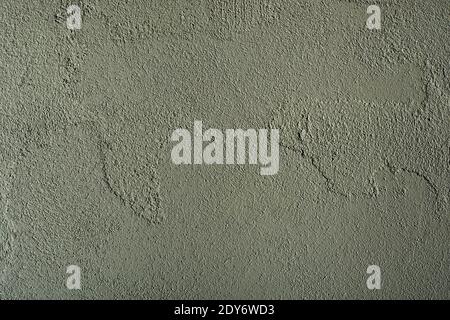 Background of green concrete wall texture. Grainy, grunge texture of aged wall with irregular shapes and lines. Stock Photo