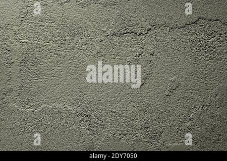 Background of green concrete wall texture. Grainy, grunge texture of aged wall with irregular shapes and lines. Stock Photo