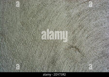 Background of green concrete wall texture. Grainy, grunge irregular texture of aged wall with pattern of circular lines. Stock Photo