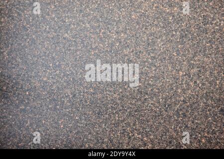 Dark brown granite with gray and black interspersed with fine fraction. Background, texture. Stock Photo