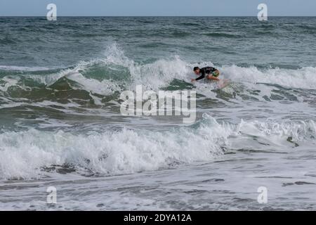 A surfer rides a wave along Hutchinson Island in Stuart, Florida, USA. Stock Photo