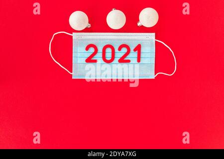 One mask with the numbers 2021 with white Christmas balls on a red background. New Year is coming. 2021 is coming. Christmas and New Year concept, cor Stock Photo