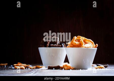 Rye crackers and baguette rusks with salt and spices in white bowls. Beer snacks. Vintage wooden background. Selective focus. Stock Photo